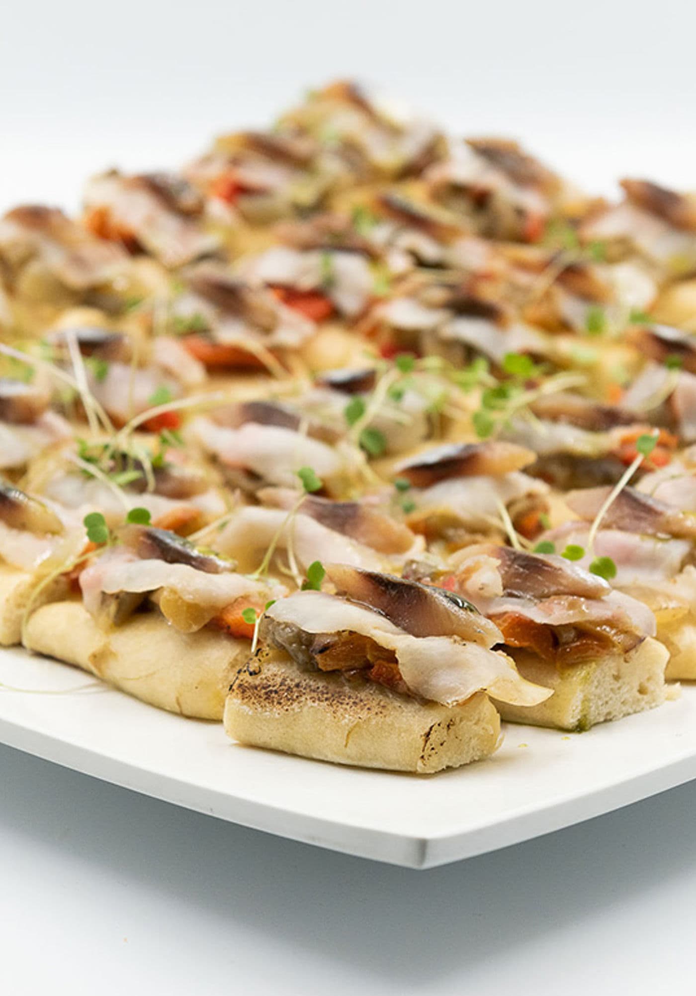 Coca de escalivada, panceta ibérica y sardina ahumada elaborada por el catering Kook´s